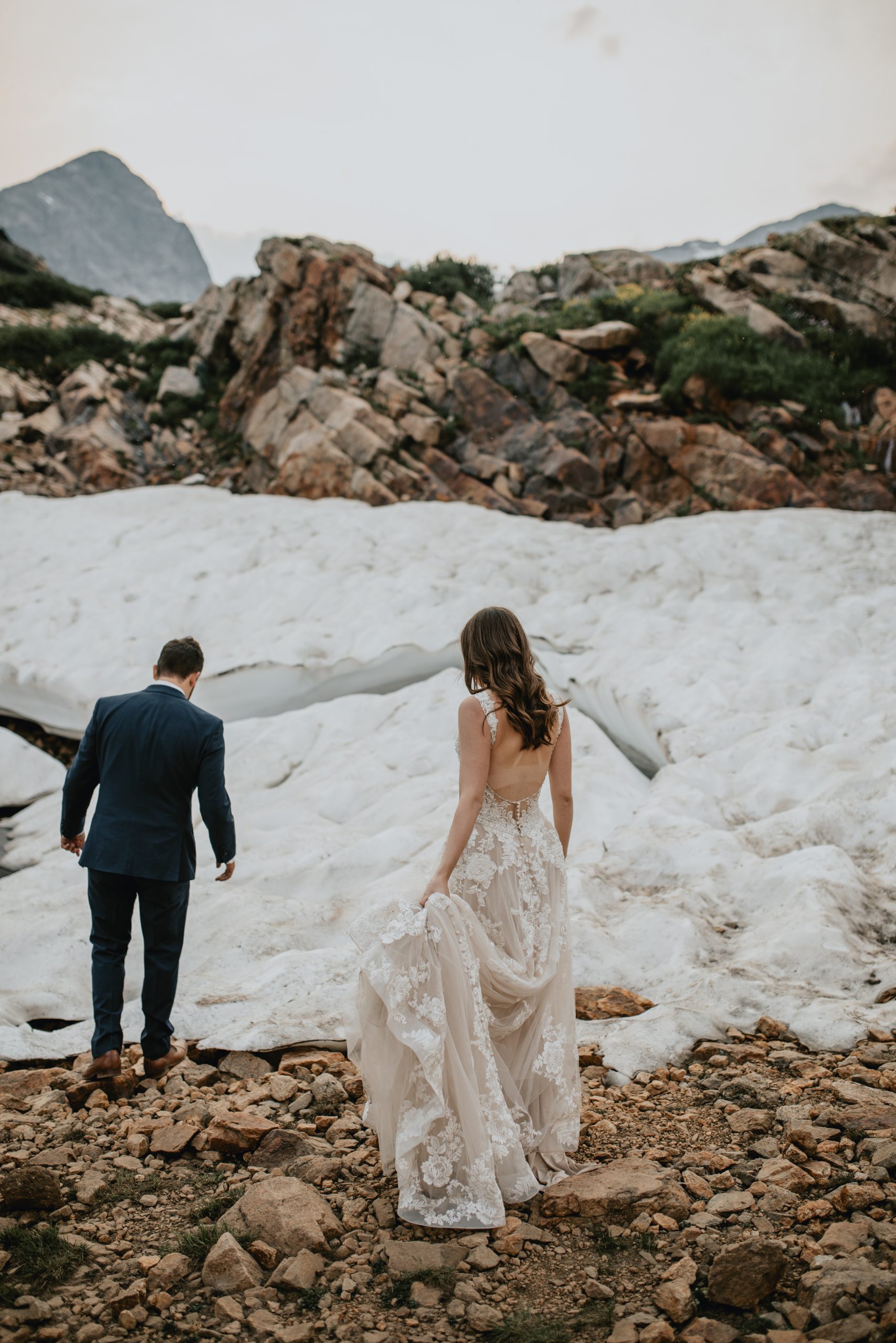 Couple in wedding attire getting married at the top of a mountain