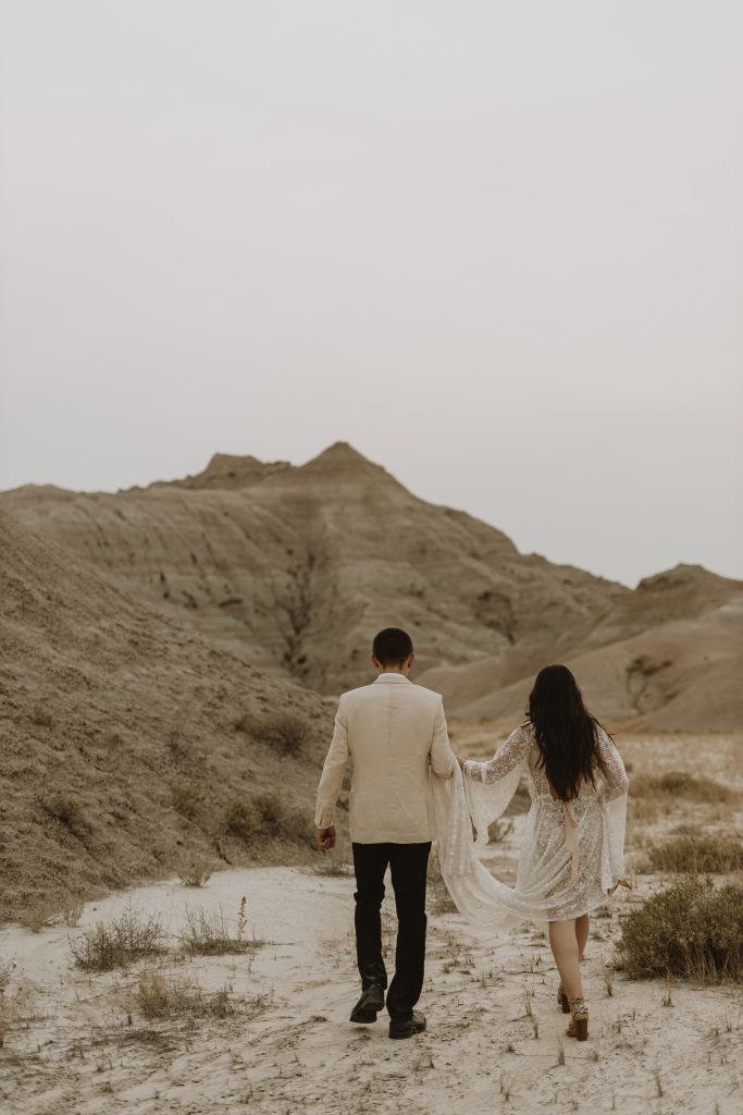 Couple in wedding attire walking through national park on elopement ceremony day
