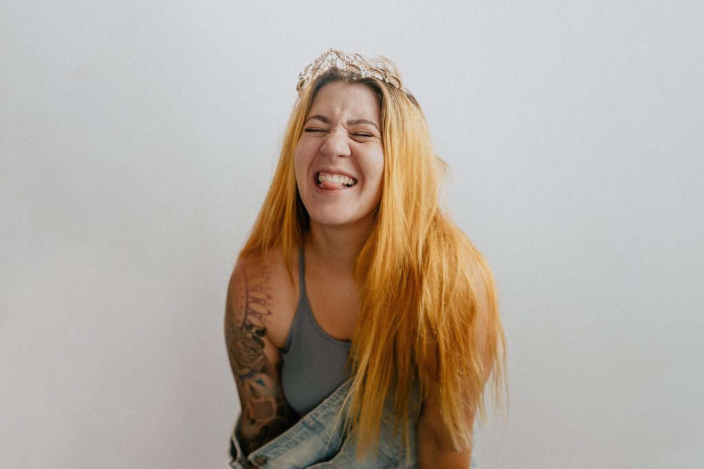 Image of woman with orange hair sticking her tongue out playfully at the camera