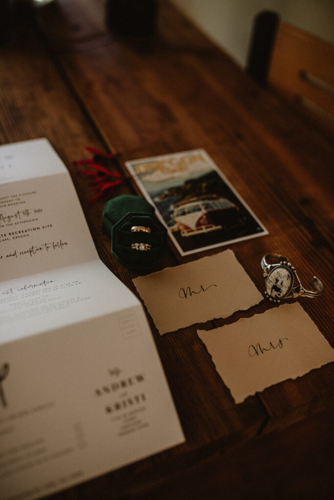 Close up of details from a wedding, including jewelry, mr and mrs papers, and wedding rings.