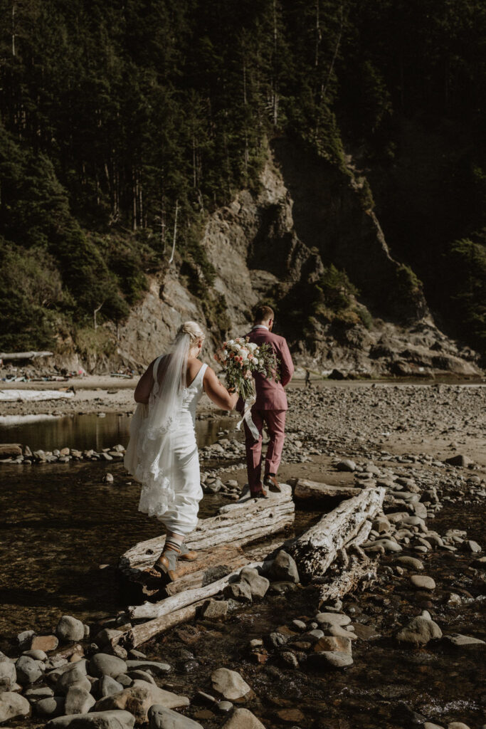 A couple walks across a river on their elopement day.