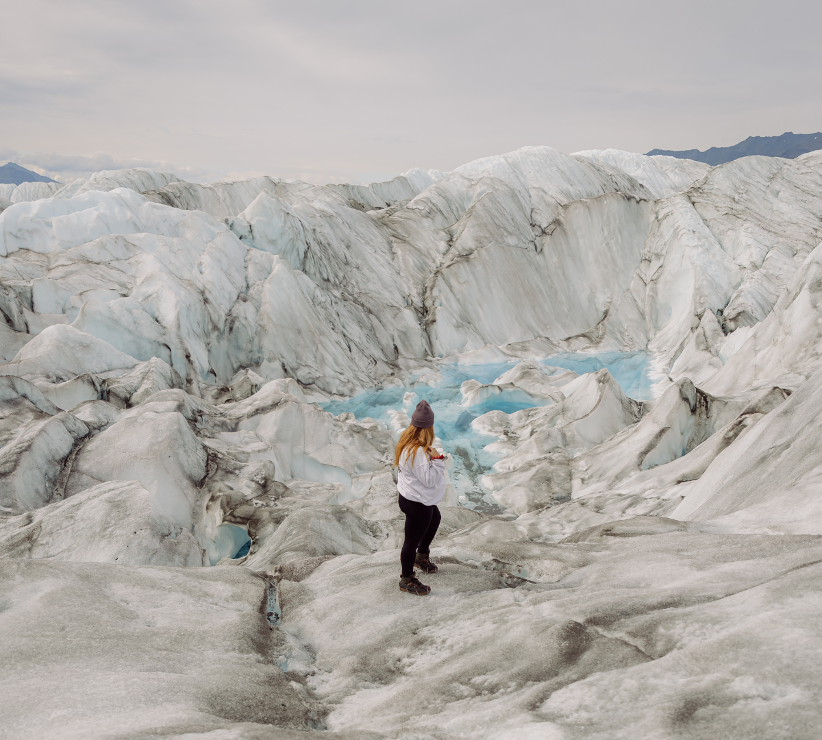 Woman on top of glaciers looking out to the water