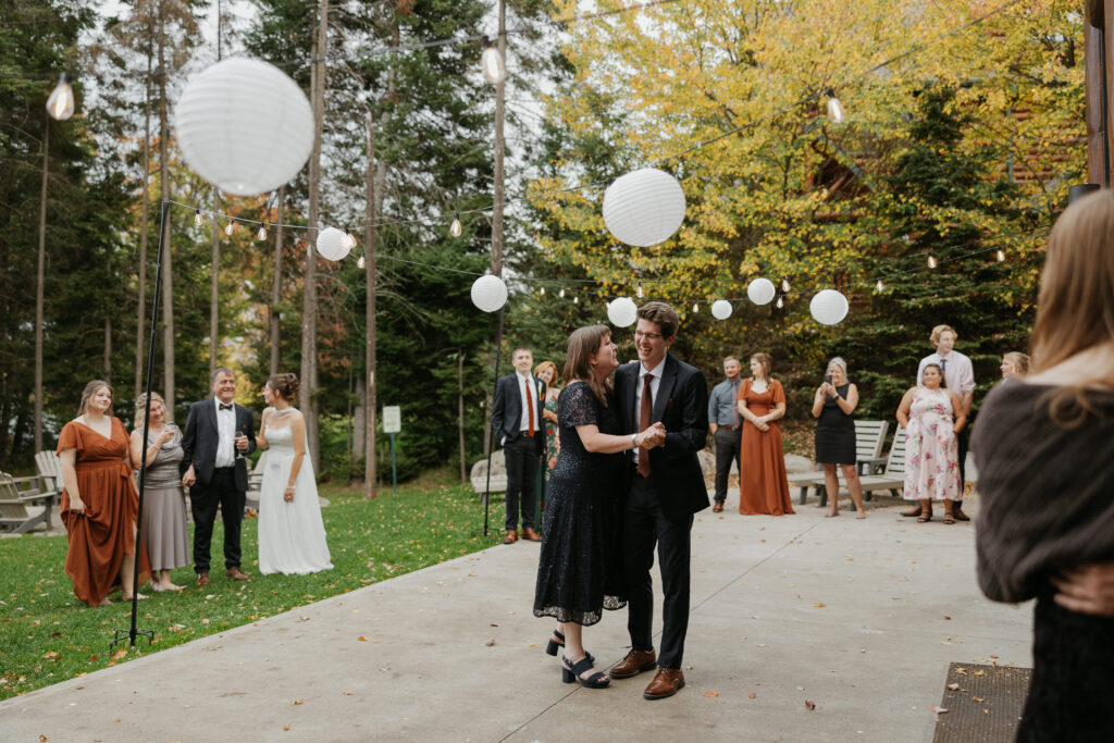 groom laughing and dancing with his mom on the back patio during an airbnb micro wedding