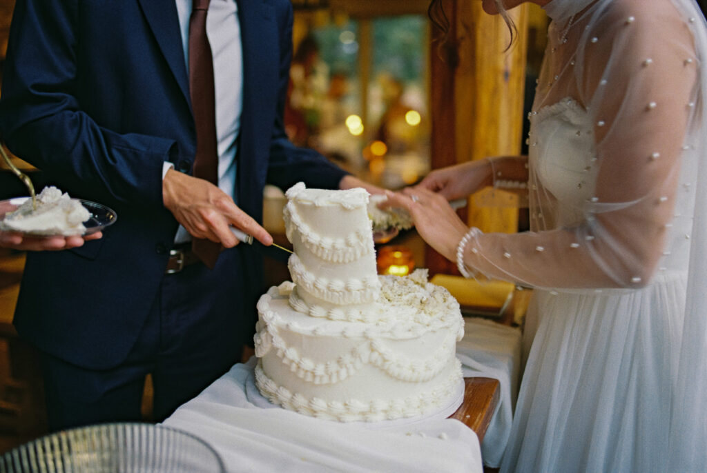 Film photos of a couple cutting their cake during their micro wedding in their airbnb